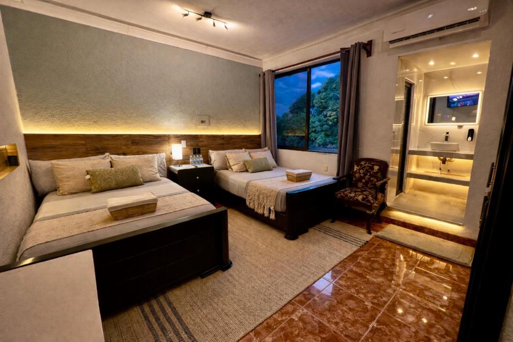 a hotel room with two beds and a window at Casa Solar Boutique Eco-Hotel Exclusiva y elegante in Minatitlán
