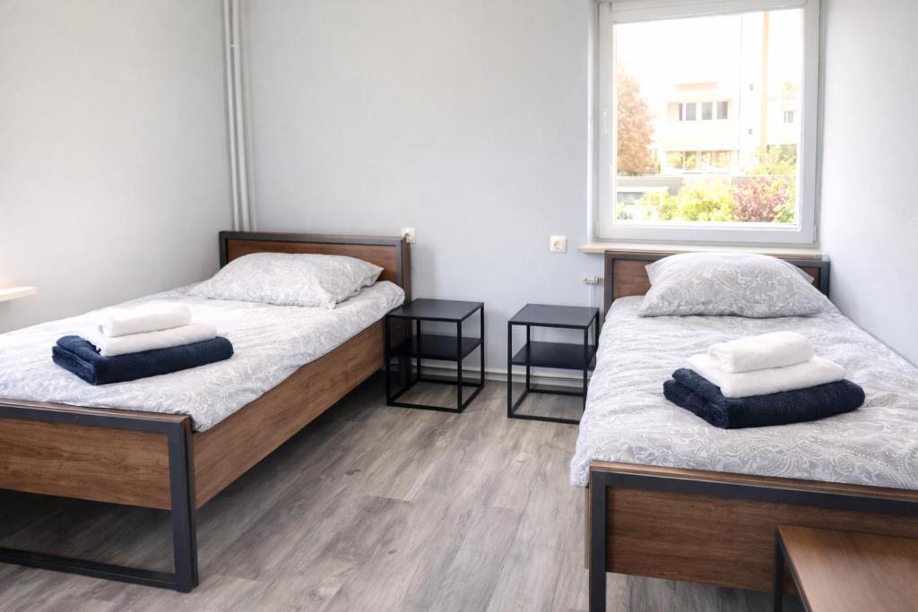 two twin beds in a room with a window at Apartments in Leuna in Leuna
