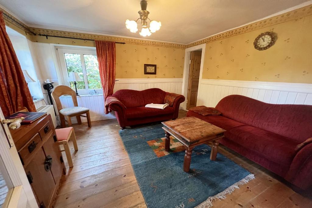 a living room with a red couch and a table at Ferienhaus-„Alte-Schmiede“ in Westerland