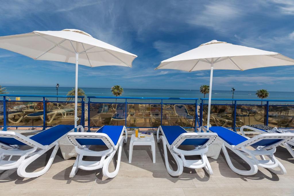 a group of chairs and umbrellas on a balcony at Hotel Yaramar - Adults Recommended in Fuengirola