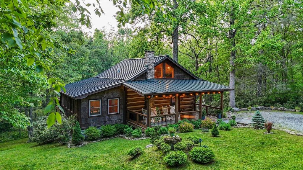 a log cabin in the middle of a forest at Hemlock Hill Cabin in Blowing Rock