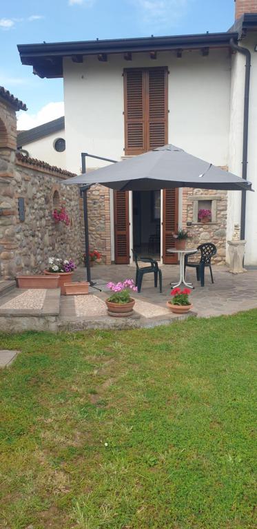 a patio with an umbrella in front of a house at Bracchi's room franciacorta in Cazzago San Martino