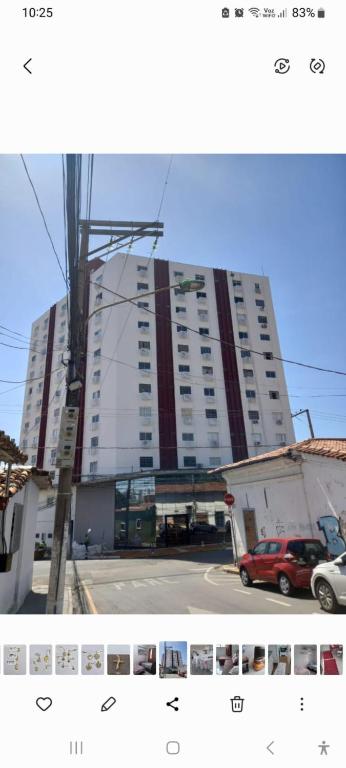 a large building with a red car parked in front of it at no centro de Cuiabá aptº mobiliado in Cuiabá