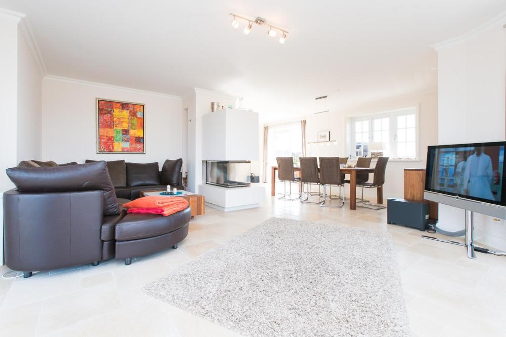 a living room with a couch and a tv at Haus-Meerblick in Rantum