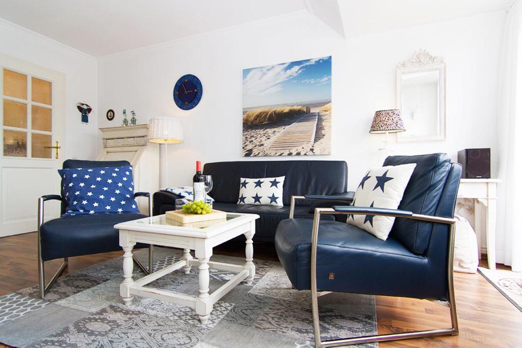 ein Wohnzimmer mit zwei Stühlen und einem Tisch in der Unterkunft Haus Seemöwe in Archsum