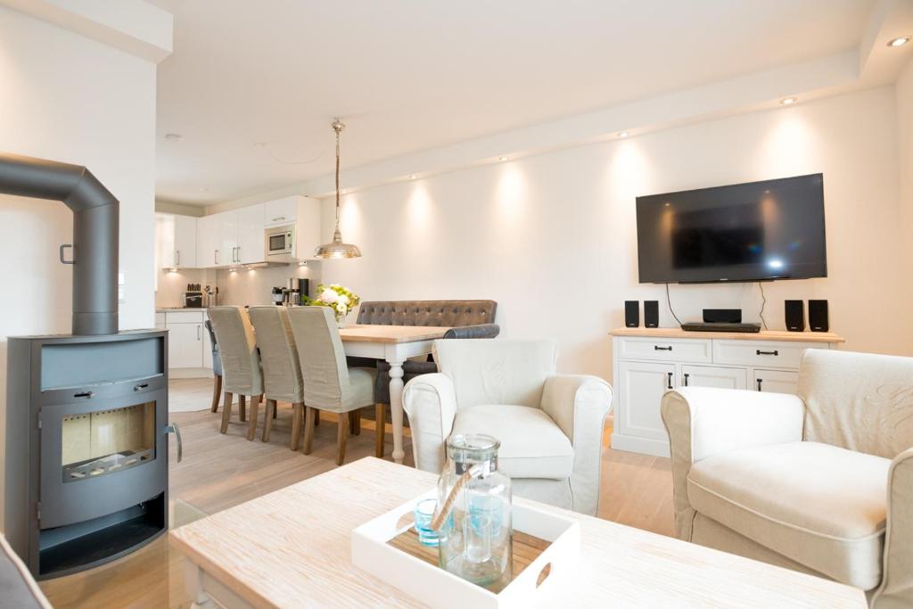 a living room with a fireplace and a dining room at Haus-Seestern in Tinnum