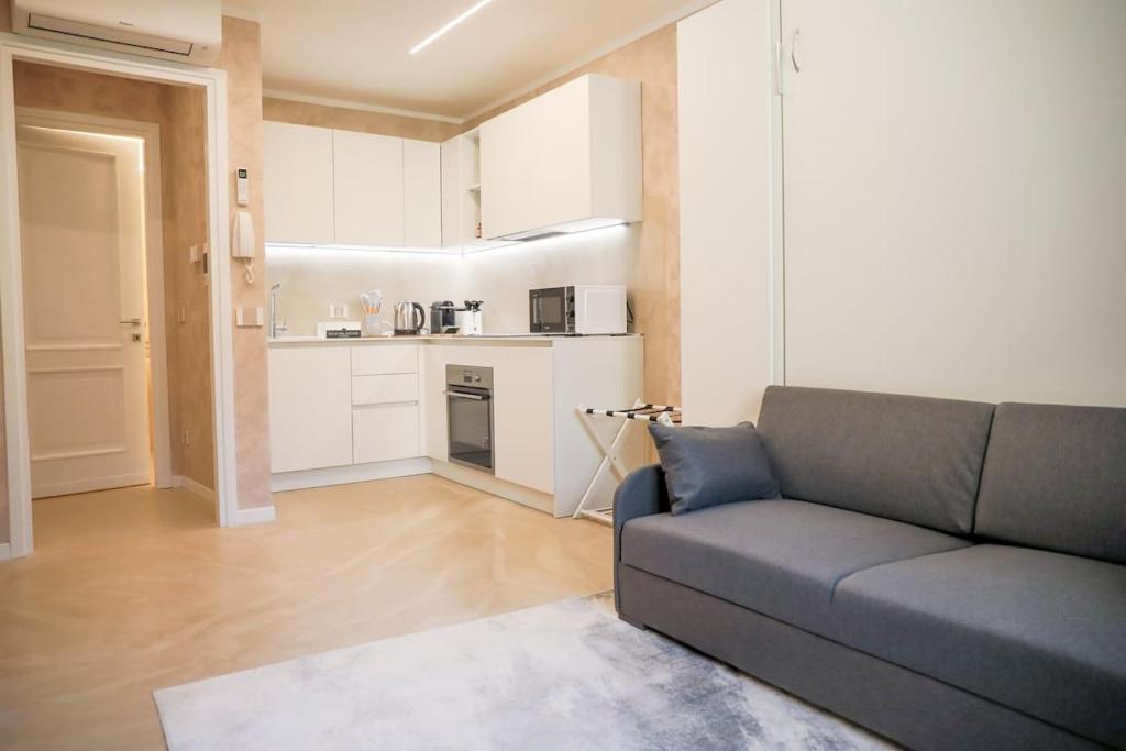 a living room with a couch and a kitchen at BLUE WAVE by Design Studio in Bellano