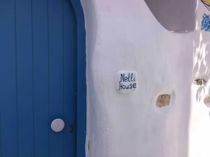 a white shirt with a wall house sign on it at Maison d'Elli in Mesochórion