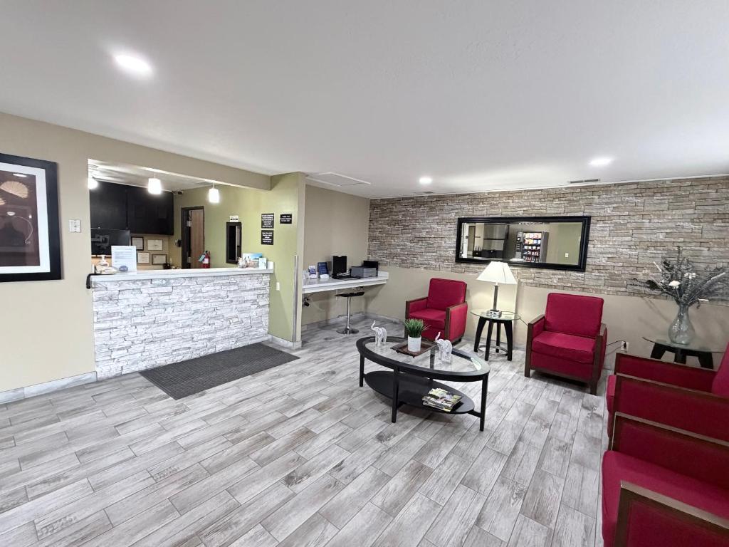 a waiting room with two red chairs and a table at Super 8 by Wyndham Logan in Logan