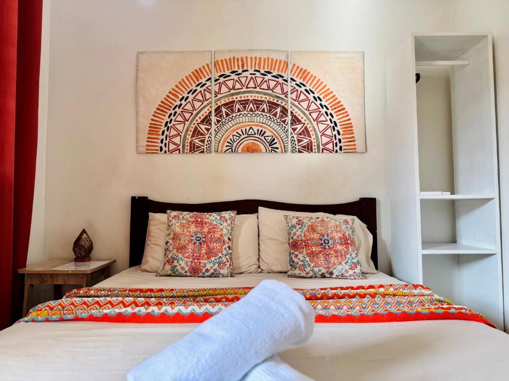 a bedroom with a bed with a painting on the wall at Lavajas Guest House in San Juan