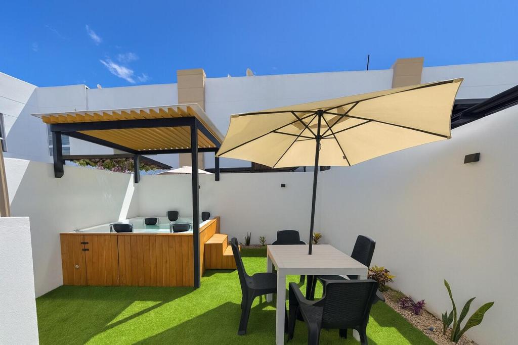 a patio with a table and an umbrella at Casa Bethel 92 in Ricaurte