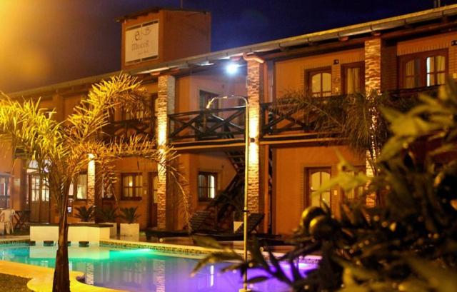 a building with a swimming pool at night at El Mirador Apart Hotel in Federación