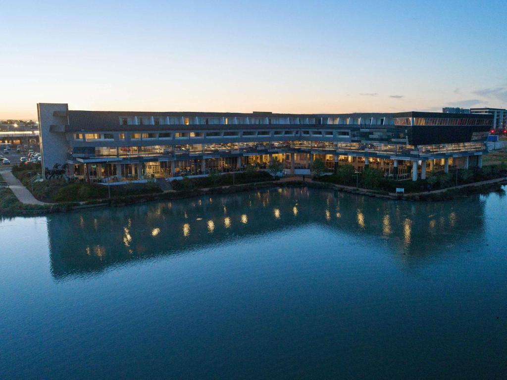 a large building with lights in the water at Mercure Melbourne Caroline Springs in Caroline Springs