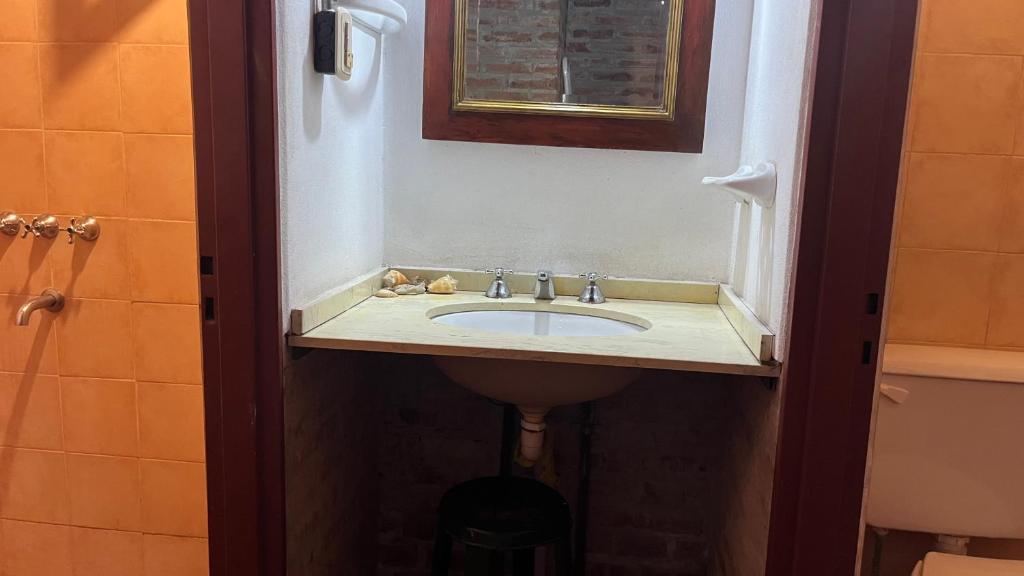a bathroom with a sink and a mirror at El Campito in Villa Icho Cruz
