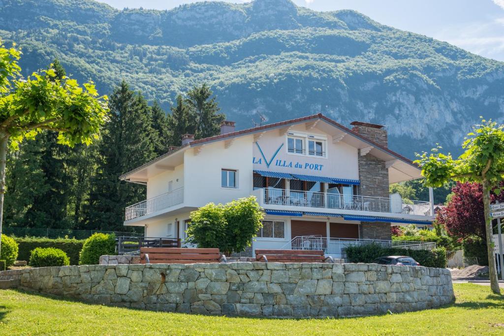 een huis met een berg op de achtergrond bij La villa Du Port in Veyrier-du-Lac