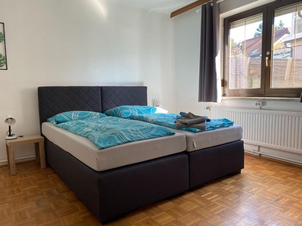 a bedroom with a bed with a blue comforter at Apartmenthaus MITTERFELD in Mitterfeld