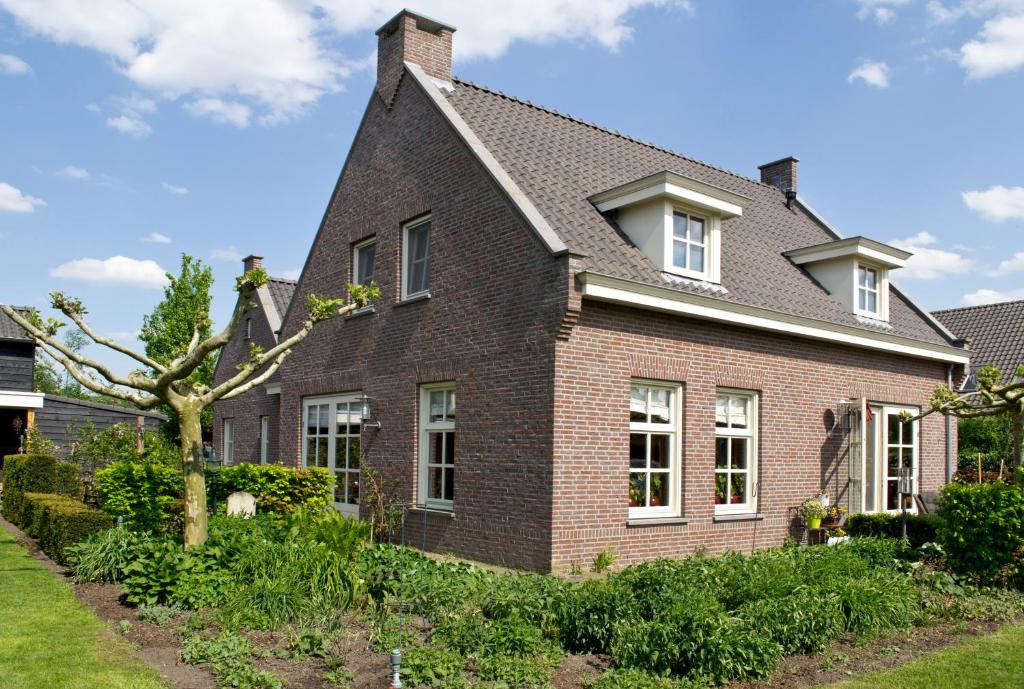 een stenen huis met een gambrel dak bij Bed & Breakfast Maryland in Heusden