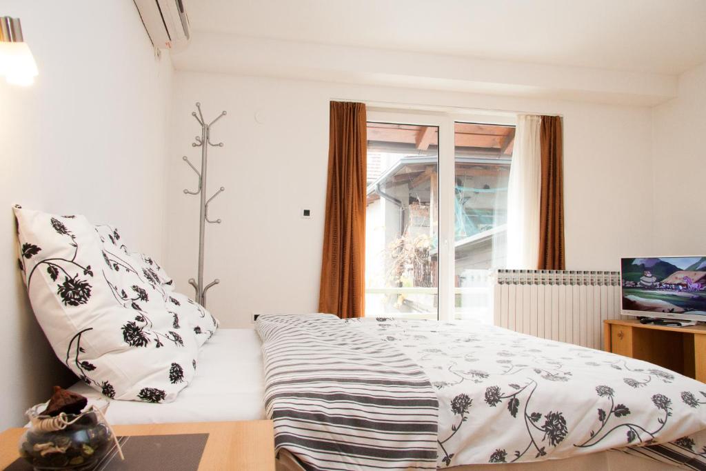 Schlafzimmer mit einem Bett und einem Fenster in der Unterkunft Rooms Garden Zagreb Airport in Velika Gorica