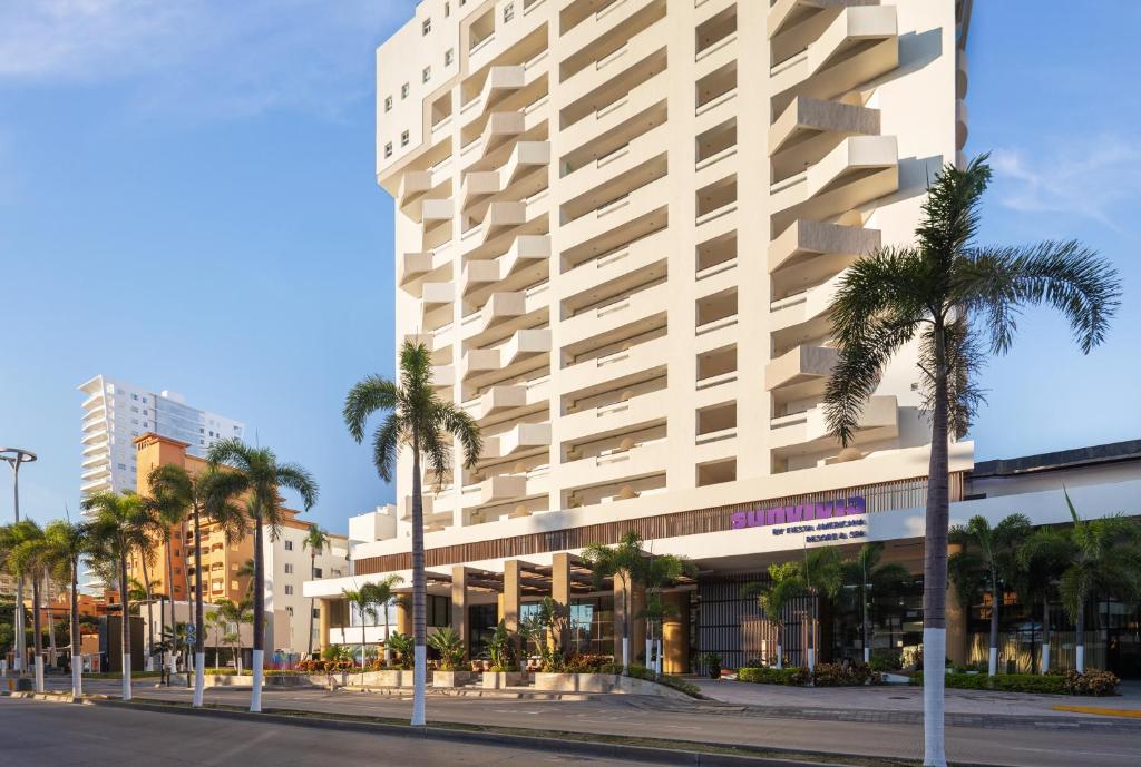 un gran edificio blanco con palmeras delante en Sunvivia by Fiesta Americana Mazatlán, en Mazatlán
