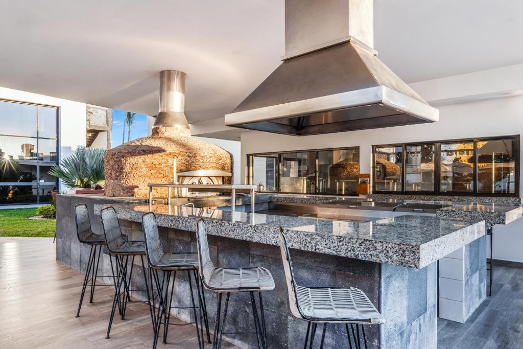 Una cocina con una gran encimera con taburetes. en Sunvivia by Fiesta Americana Mazatlán, en Mazatlán