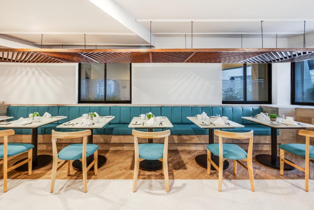 un comedor con mesas y sillas azules en Sunvivia by Fiesta Americana Mazatlán, en Mazatlán