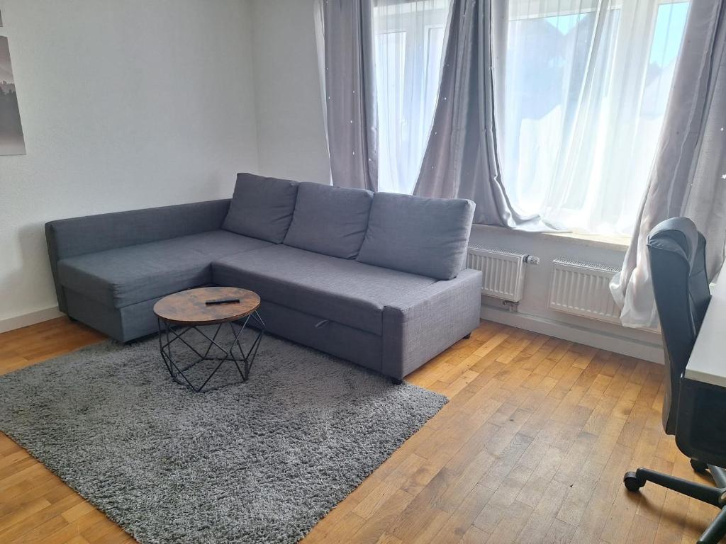a living room with a blue couch and a table at Delblaiso Suite in Memmingen