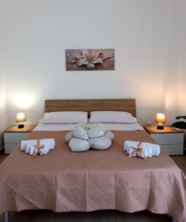a bedroom with a bed with pillows on it at Blossom House in Isola delle Femmine