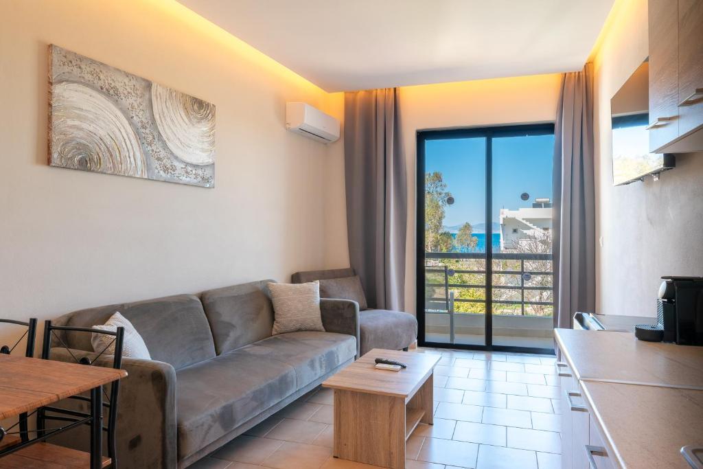 a living room with a couch and a table at Blue Wave Suites - Ixia in Ialysos