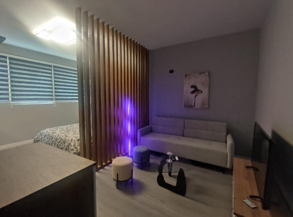 a living room with a couch and a bed at My Daily Home in Fier