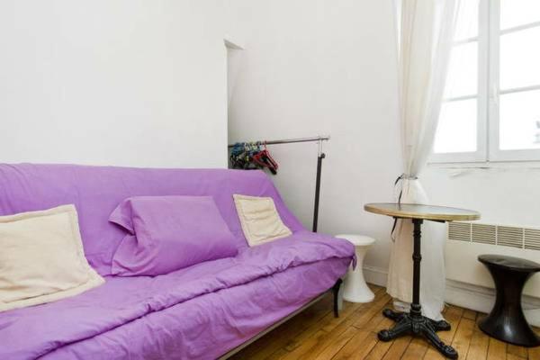 a purple couch in a living room with a table at CHAMPS ELYSEES STUDENT STUDIo in Rosières-près-Troyes