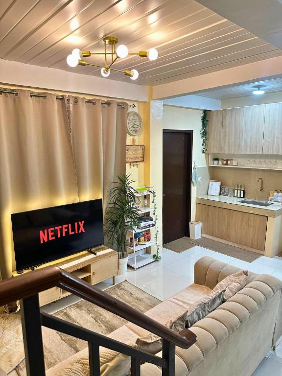 a living room with a couch and a television at Luxy Stay Gensan in Lagao II