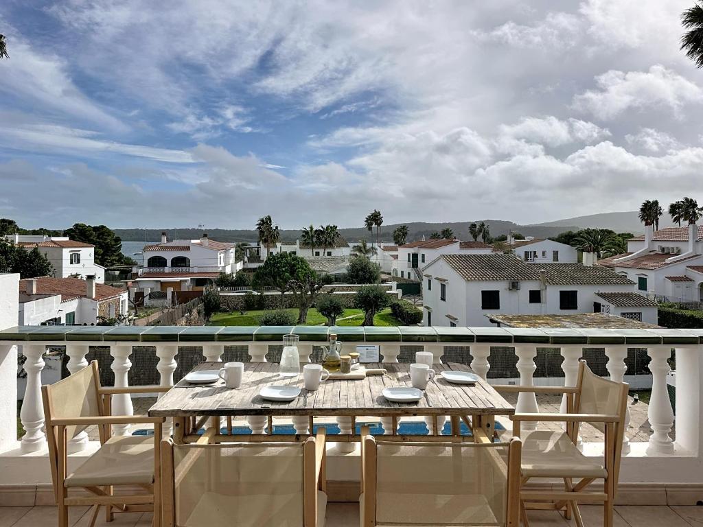 a table on a balcony with a view of a city at Apartamento con piscina SS20 in Fornells