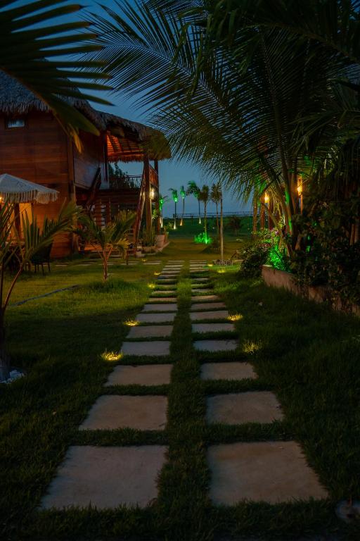 a pathway leading to a resort at night at Áurea chalés in Tutóia