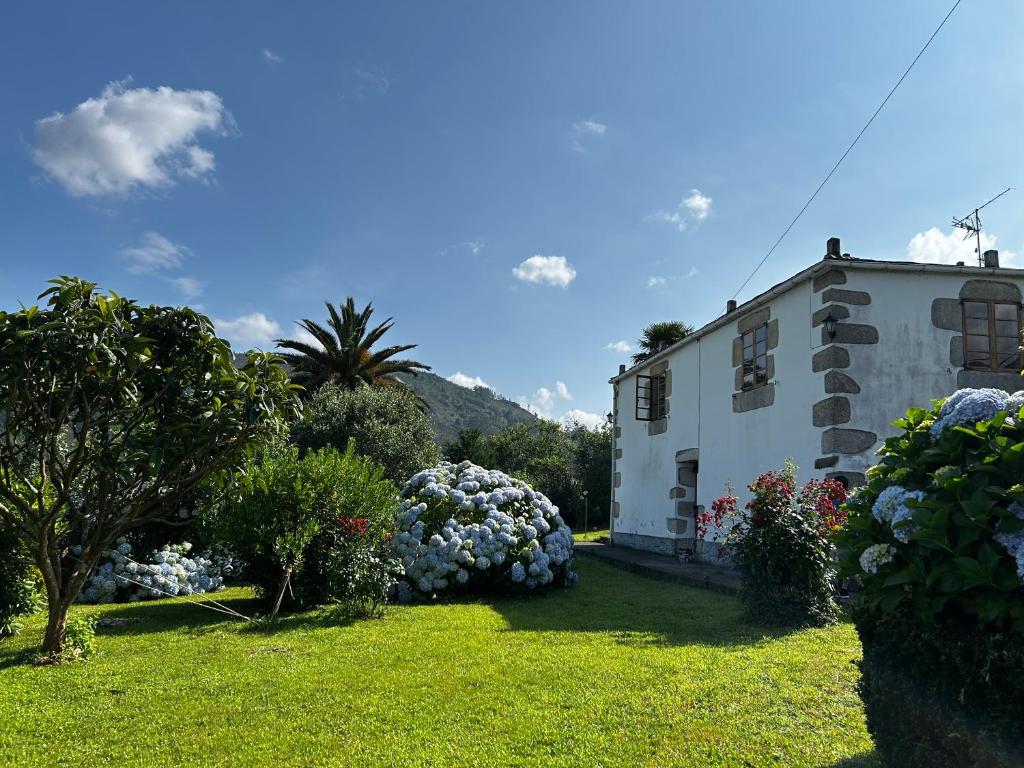 a house with a yard with bushes and flowers at Casa Conchas in Ferreira