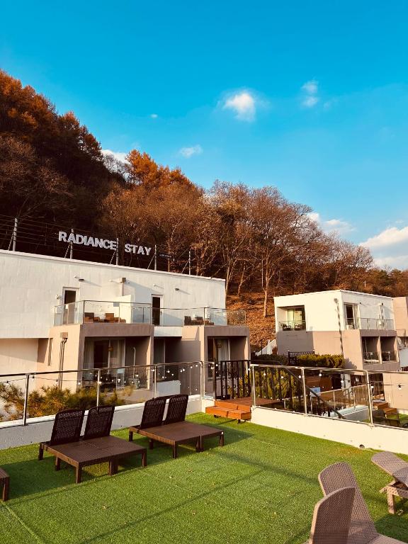 a balcony with benches on a building with grass at Radiance Stay in Paengnodam
