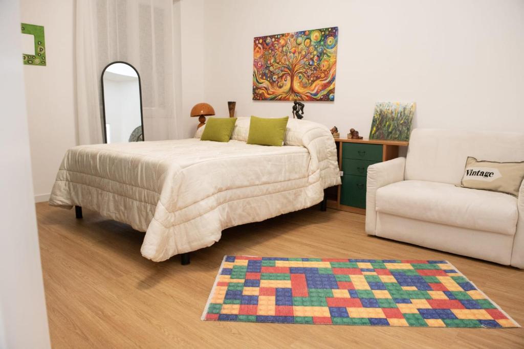 a bedroom with a bed and a couch and a chair at via Minzoni 26 in Cosenza