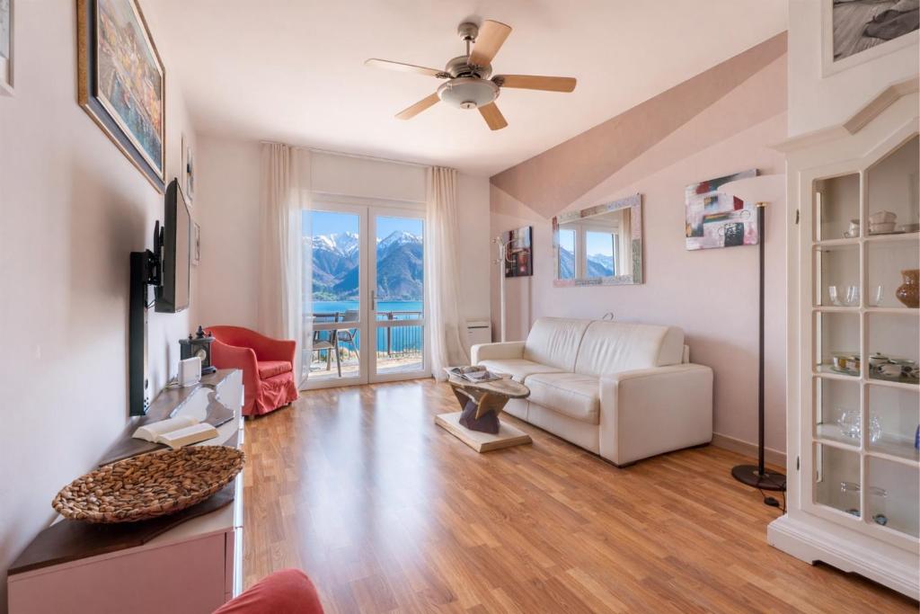 a living room with a couch and a ceiling fan at Mont&Lac Lake View Apartment in Limone in Limone sul Garda