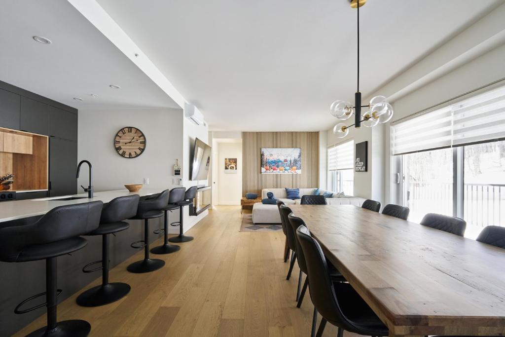 a dining room with a long table and chairs at Unité 104 in Beaupré