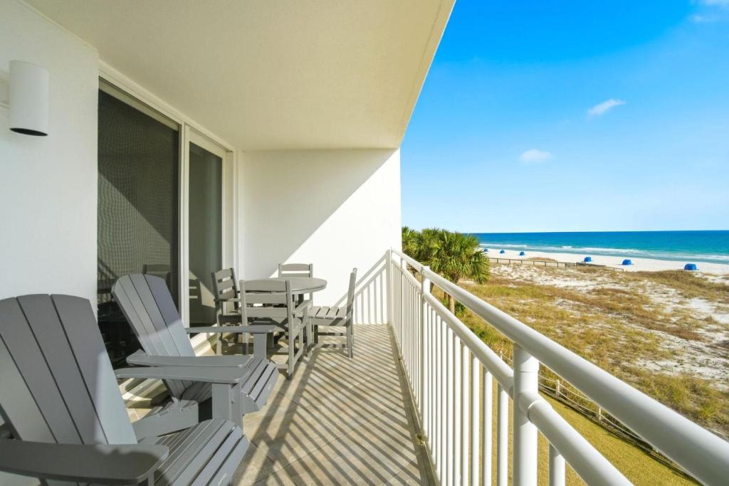 a balcony with chairs and a table and the beach at SeaSpray West 303-Gulf Front in Perdido Key