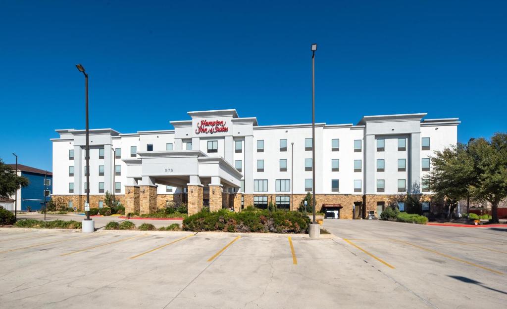 a white hotel with a parking lot in front of it at Hampton Inn & Suites New Braunfels in New Braunfels