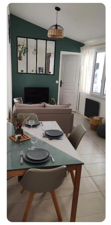 a living room with a table and a couch at Maisonnette cosy et calme in Mions