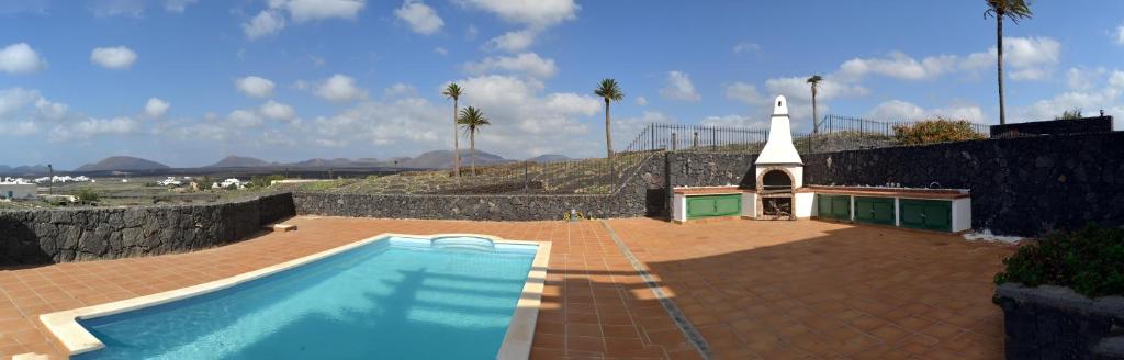 una chiesa e una piscina accanto a un edificio di Vista Timanfaya a Yaiza