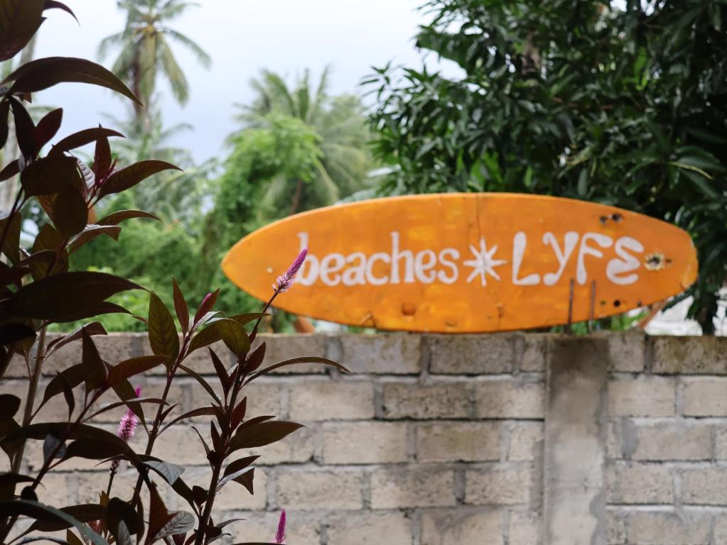 a surfboard is attached to a brick wall at beaches Lyfe Rooms in Kuta Lombok