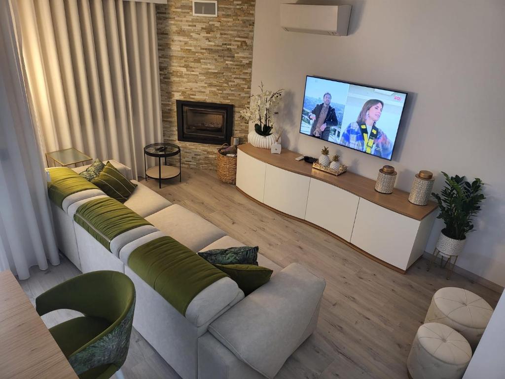 a living room with a couch and a flat screen tv at Casa do Azeite in Torre de Moncorvo
