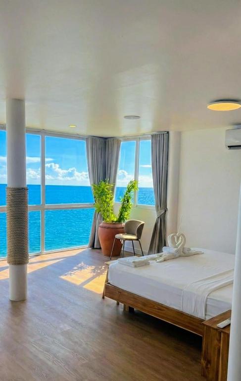 a bedroom with a bed and a view of the ocean at Beach Studio Level - WaveSide Ocean Bliss in Ko Phangan