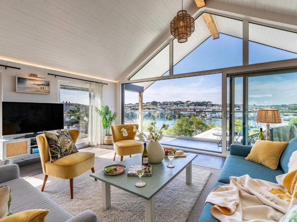 a living room with a blue couch and a large window at 5 Bed in Fowey oc-93849 in Polruan