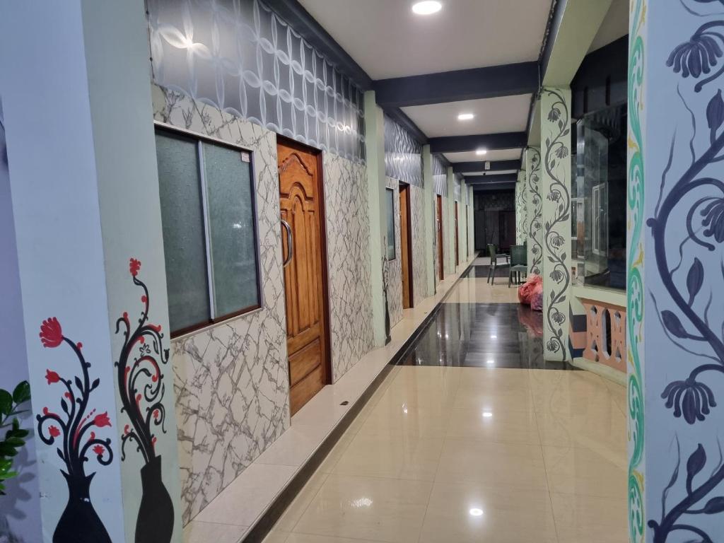 a corridor of a building with paintings on the walls at Abi Hotel & Rastaurant in Jaffna