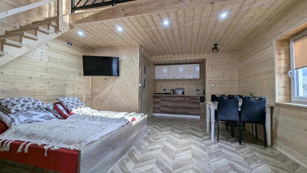 a living room with a bed and a kitchen at Domek wypoczynkowy Górskie Zacisze in Sidzina