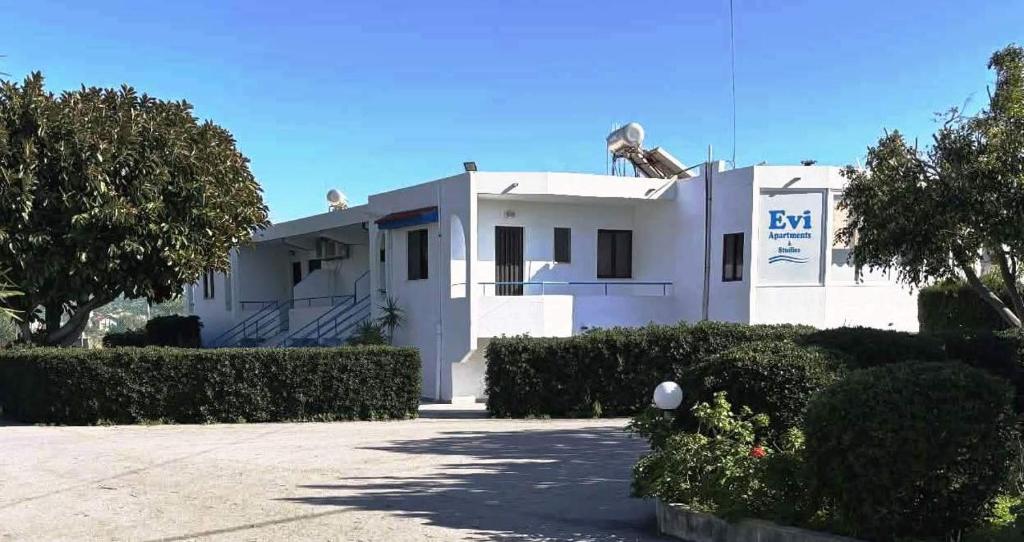 a large white house with a driveway in front of it at Evi Apartments And Studios in Theologos