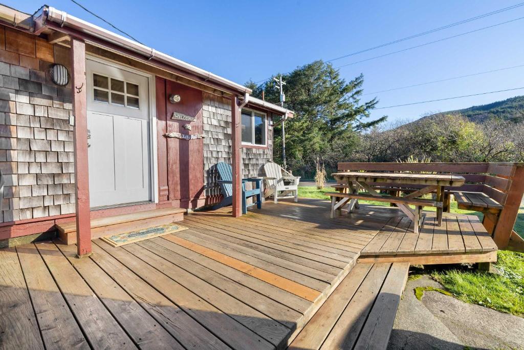 a wooden deck with a picnic table and a house at The Lily Pad in Rockaway Beach